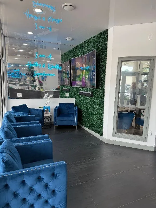 A dental office with a red chair and a tv on the wall