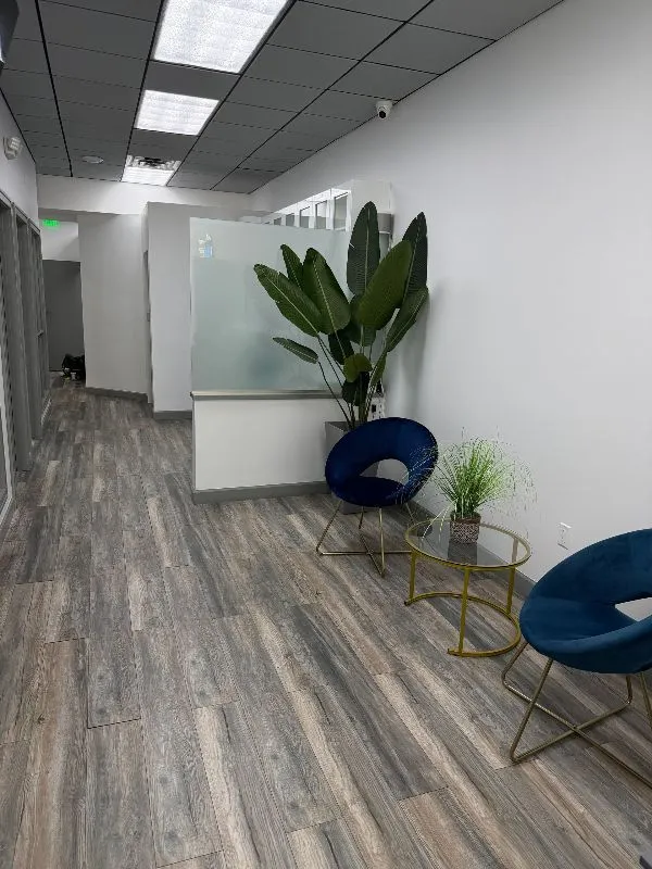 A dental office with a red chair and a tv on the wall