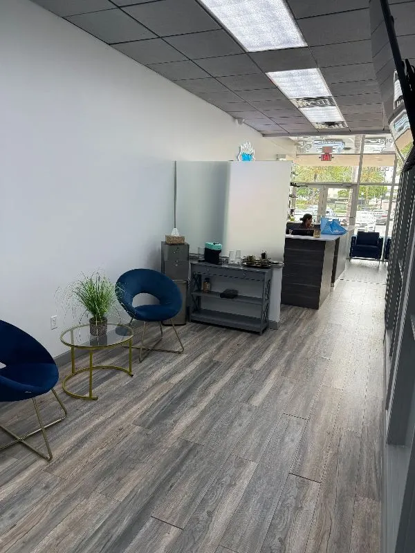 A waiting room with chairs and a table in a store.