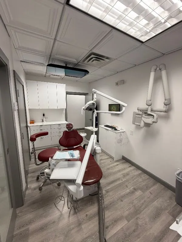 A dental office with a dental chair and x-ray machine.