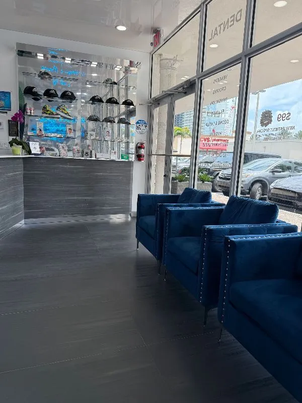 A waiting room with blue chairs and a counter in a store.