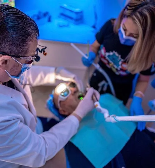 A dentist is examining a patient 's teeth in a dental office.
