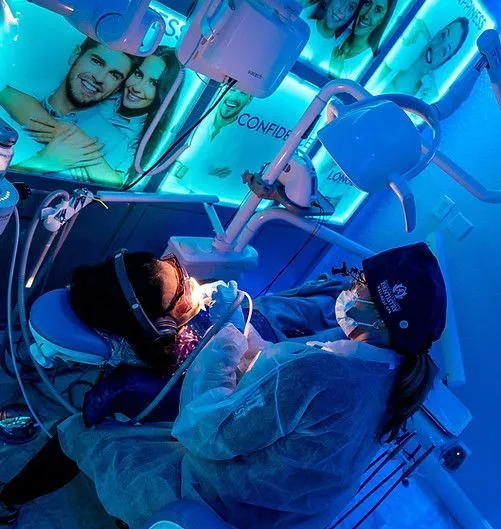 A dentist is working on a patient in a dental chair